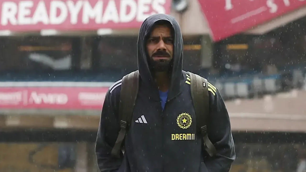 Virat Kohli looks on as the rain comes down