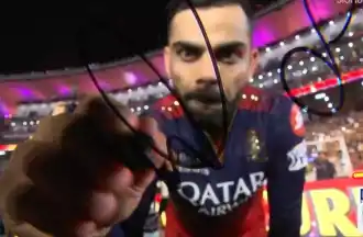 Virat Kohli signs the camera after winning IPL 2025 Final