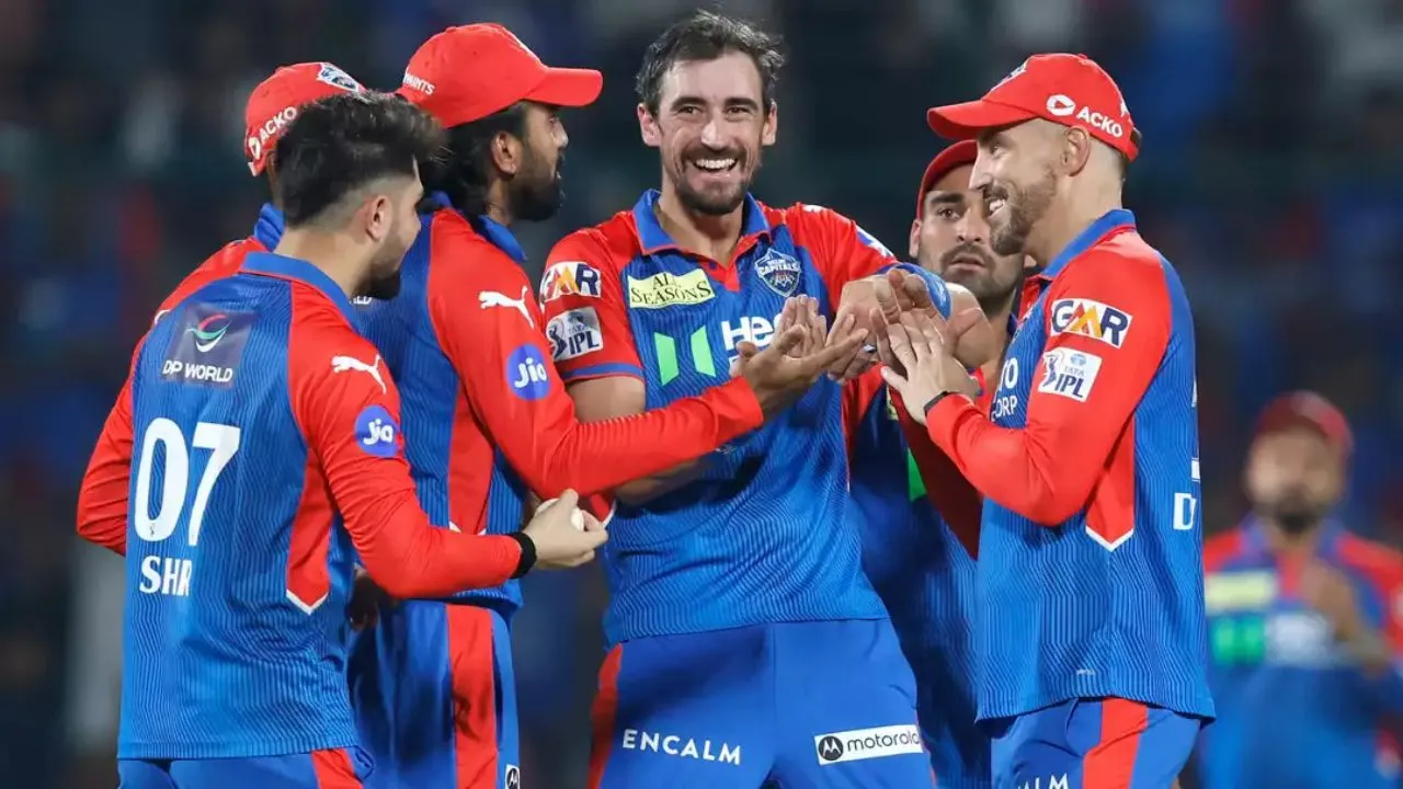 Delhi Capitals players celebrating a wicket during an IPL match, showcasing strong teamwork and high energy on the field.