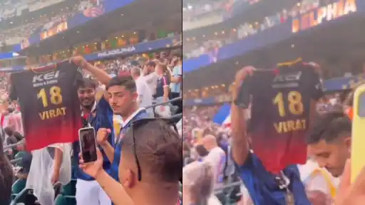 A fan holds up Virat Kohli's Royal Challengers Bengaluru red jersey in the crowd during the France vs Iraq FIFA World Cup 2026 match