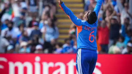 Deepti Sharma raises both arms in celebration wearing India jersey number 6 during an ICC tournament match — crowd cheering in the background