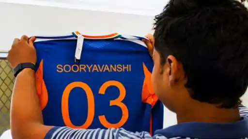 Vaibhav Sooryavanshi looking at his blue India jersey with name "SOORYAVANSHI" and number 03 ahead of the Ireland T20I series