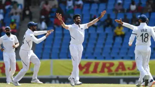 Jasprit Bumrah celebrates a Test wicket with India teammates, as reports suggest he could be the next star cricketer to settle abroad after Virat Kohli