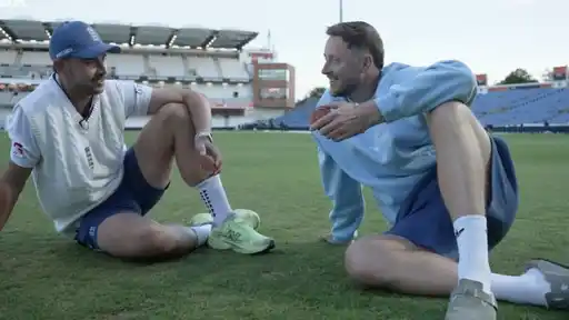 Ollie Robinson and Josh Tongue sitting on the Headingley outfield, each holding a half of the split match ball after their twin five-wicket hauls against Pakistan