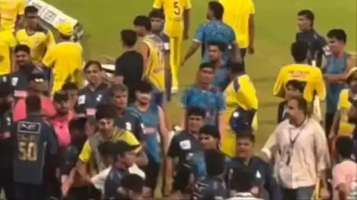 Players and officials gather on the field during the heated argument between Yash Dhull and Priyansh Arya in DPL 2026