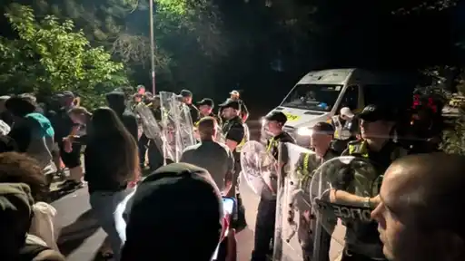 Police officers with shields manage a crowd gathering in England during the incident involving Pakistan's U19 squad
