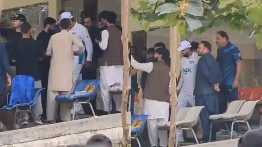 Babar Azam, in cricket whites, greeted by people near the pavilion during his President's Trophy comeback match in Abbottabad