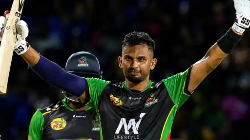 Dasun Shanaka raises his bat in celebration after smashing the fastest century in CPL history against St Lucia Kings