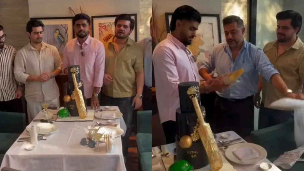 Babar Azam at a birthday gathering: standing beside a black cake with a gold bat design on the left, and a man handing him a gold bat on the right