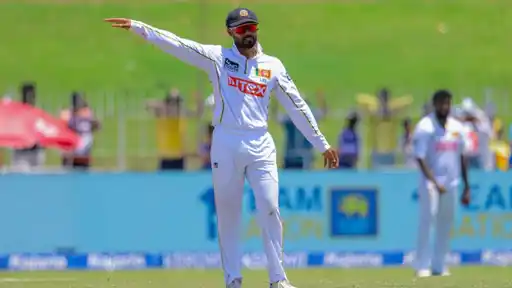 Dhananjaya de Silva in white Test kit and red sunglasses points to set the field during a Test match, before stepping down as Sri Lanka Test captain ahead of the Pakistan series