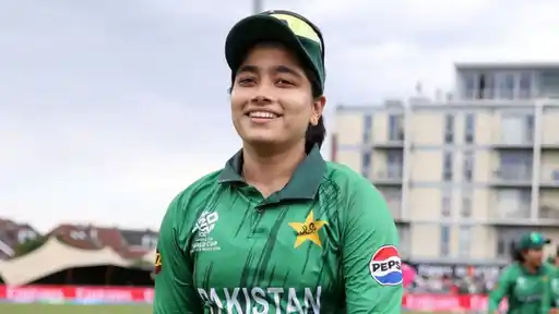 Smiling Pakistan captain Fatima Sana in green Pakistan kit with a Women's T20 World Cup England and Wales 2026 logo, ahead of joining Perth Scorchers for WBBL 2026/27