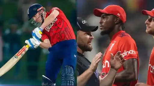 England players in red and navy kit, with a batter playing a shot on the left and fielders and a coach in a huddle on the right