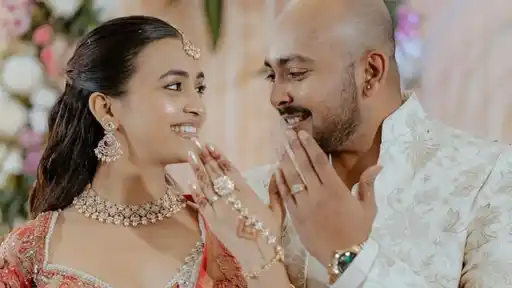 Prithvi Shaw and Akriti Agarwal smiling at each other in traditional outfits, showing their engagement rings.
