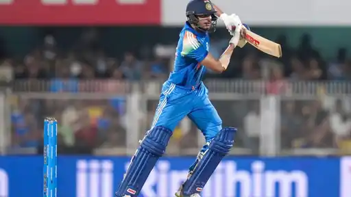 Shubman Gill in India's blue kit and helmet plays a drive during his fastest-ever ODI double century against West Indies in the 2nd ODI at Guwahati